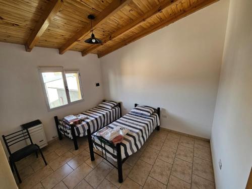 a room with two beds and a table in it at La Juanita in Junín de los Andes