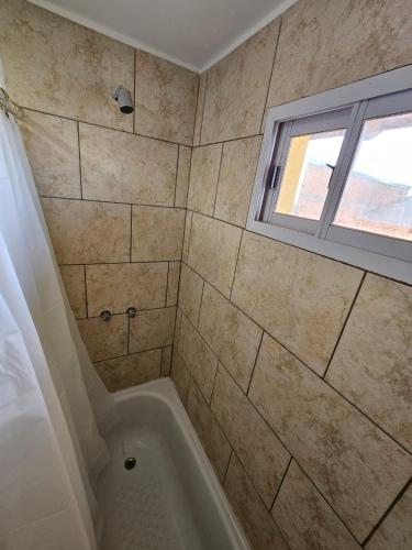Un baño con bañera y ventana. en La Juanita, en Junín de los Andes