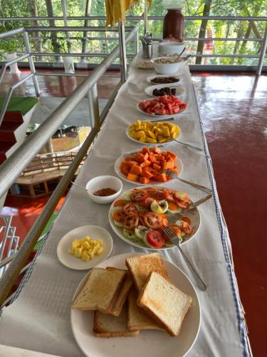 a long table with plates of food on it at Marari Beach Villas in Mararikulam