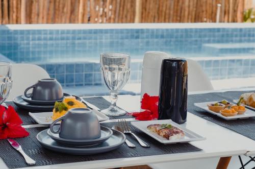 a table with plates of food and wine glasses at POUSADA AMAR NORONHA in Fernando de Noronha