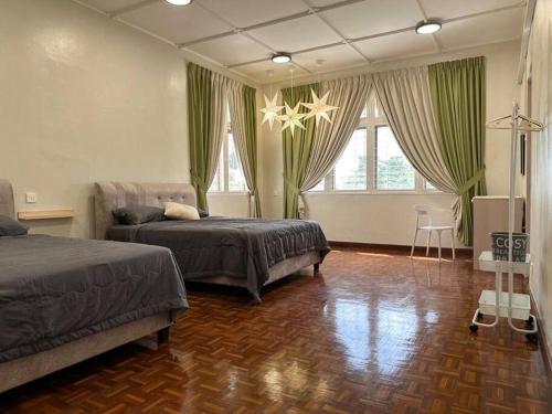 a bedroom with two beds and a couch and windows at The Hidden 7 in Taiping