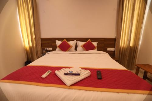 a hotel room with a bed with two remote controls at J Park Auroville Beach in Kottakupam