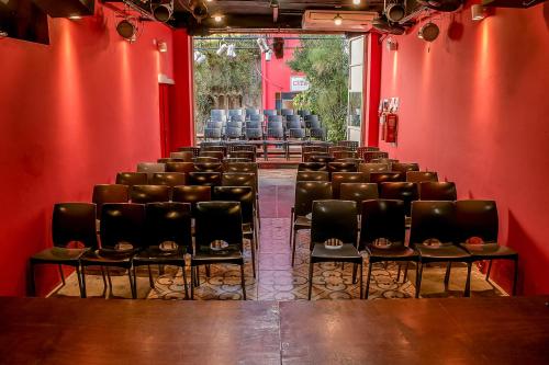 um quarto vazio com cadeiras e uma parede vermelha em Casa de Arte CiTá, bed and breakfasts em San Miguel de Tucumán