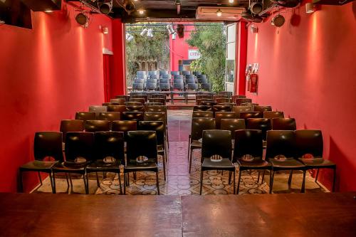 an empty room with chairs and a red wall at Casa de Arte CiTá, bed and breakfasts in San Miguel de Tucumán