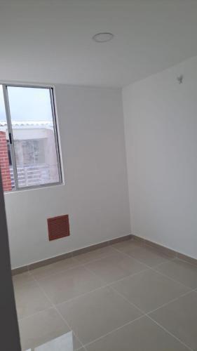 een kamer met een witte muur en een raam bij Apartamento cómodo y económico in Barranquilla