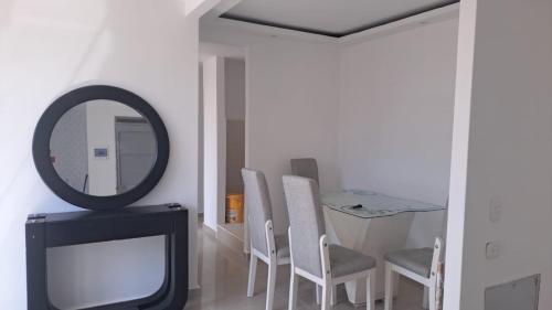 Habitación con espejo, TV y sillas. en Apartamento cómodo y económico en Barranquilla