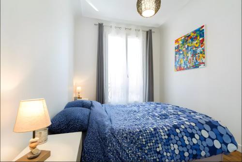 - une chambre avec un lit bleu et une table avec une lampe dans l'établissement Appartement 2 pièces avec vue Tour Eiffel, à Paris