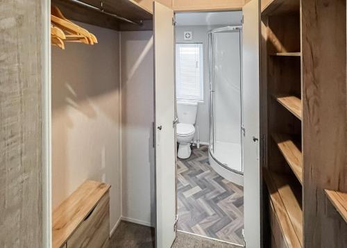 a small bathroom with a toilet and a shower at Shear Barn Holiday Park in Hastings