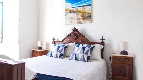 a bedroom with a bed with blue and white pillows at Casa da Paz in Labrugeira