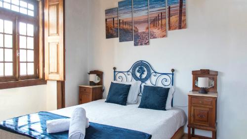 a bedroom with a bed with blue pillows at Casa da Paz in Labrugeira