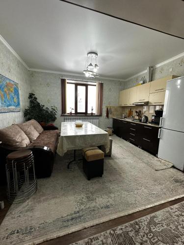 a kitchen with a couch and a table and a refrigerator at Balu in Karakol