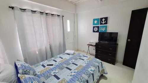 1 dormitorio con 1 cama y TV en Apartamentos Turisticos Buena Vista, en San Andrés