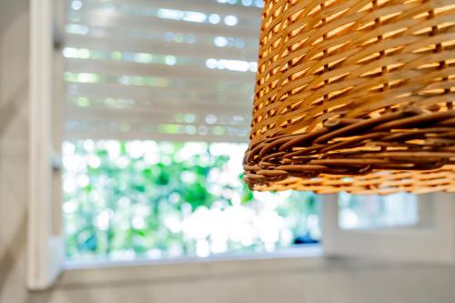 a close up of a wicker light fixture in front of a window at Casa de Arte CiTá, bed and breakfasts in San Miguel de Tucumán