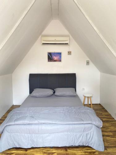 una camera da letto con un grande letto in mansarda di IT SWISS GARDEN a Perai
