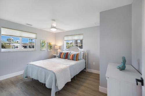 a bedroom with a bed and two windows at New Listing! Beach Walk Newly Renovated - Walk To Vanderbilt Beach! in Naples