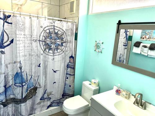 a bathroom with a toilet and a shower curtain at Cedar Key Florida Condo at Park Place in Cedar Key