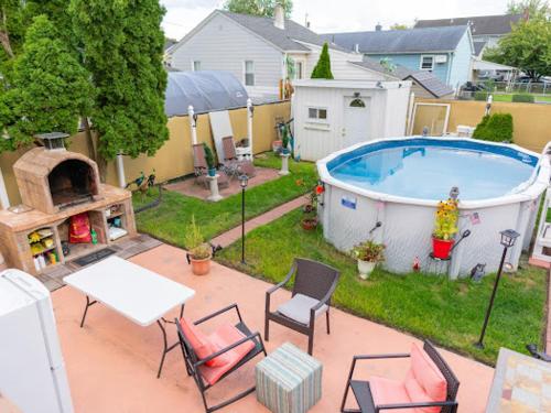 un patio trasero con piscina, mesa y sillas en Fairmount Place, en Fair Lawn