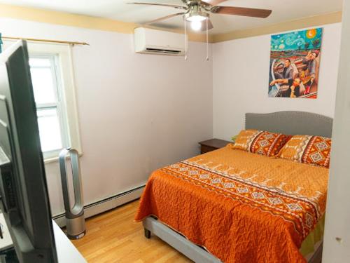 1 dormitorio con 1 cama y ventilador de techo en Fairmount Place, en Fair Lawn