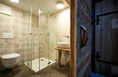 a bathroom with a sink and a toilet and a shower at Alphotel & Bergrestaurant Sankt Martin 