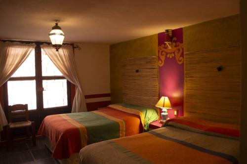 a hotel room with two beds and a window at Posada del Fraile in Tepotzotlán