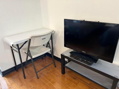 a tv sitting on a table next to a white chair at APD HOTEL in Montréal