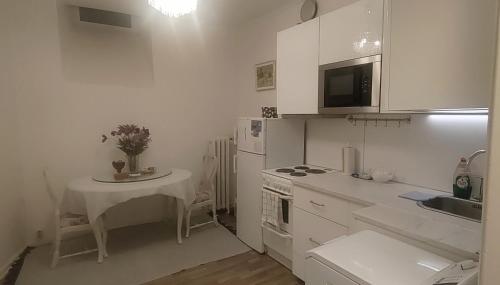 eine weiße Küche mit einem Tisch und einem Waschbecken in der Unterkunft Finland, Helsinki center in Helsinki