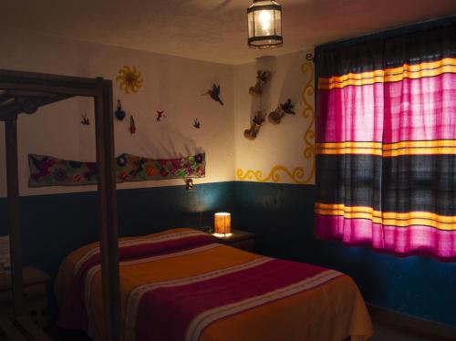a bedroom with a bed and a colorful window at Posada del Fraile in Tepotzotlán