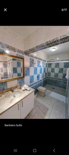 a bathroom with a sink and a mirror and a tub at Conforto em local privilegiado in Itajaí