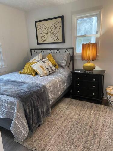 Dormitorio con cama y mesita de noche con lámpara en Almost Bearadise, en Pikeville