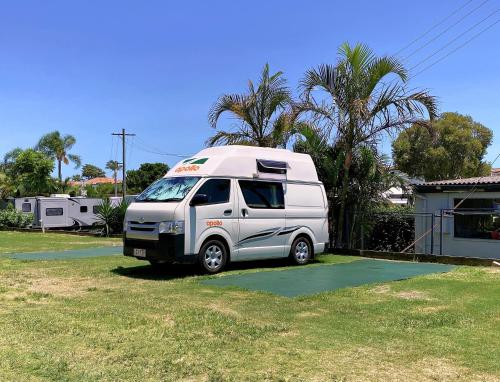a white van parked in a yard next to a house at Nobby Beach Holiday Village in Gold Coast