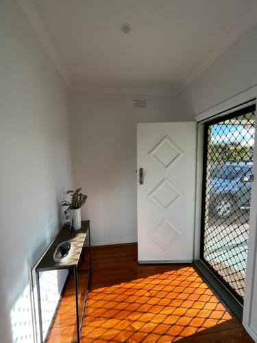 a room with a door and a table and a window at North Central Spacious Charmer - Walk to GV Health in Shepparton