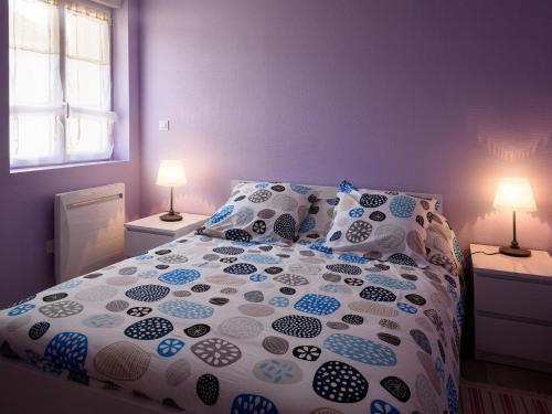 a bedroom with a bed with a white and blue comforter at Spacieuse maison rénovée, nature verdoyante - FR-1-489-176 in Valigny