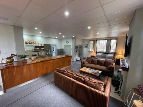 a living room with two couches and a kitchen at Post Office Boutique Accommodation in Hat Head