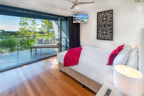 a bedroom with a bed and a balcony at Pinnacle Apartments on Hamilton Island by HIHA in Hamilton Island
