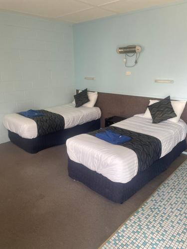 three beds sitting in a room with at Springsure Hotel Motel in Springsure