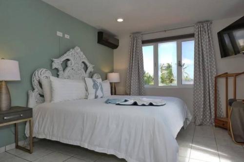 パーム・イーグル・ビーチにあるVilla Saliñaのベッドルーム(白いベッド1台、窓付)
