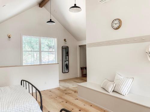 1 dormitorio con 1 cama y reloj en la pared en Homestead Barn Loft, en Sonora