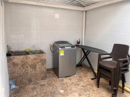 um quarto com uma lata de lixo e uma mesa e cadeiras em Descansa con tranquilidad em Villavicencio