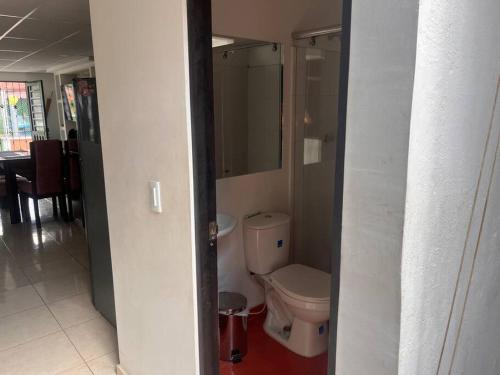a bathroom with a toilet in a hallway at Descansa con tranquilidad in Villavicencio