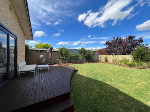 a wooden deck with a bench on a lawn at North Central Spacious Charmer - Walk to GV Health in Shepparton