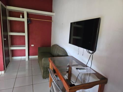 sala de estar con sofá y TV de pantalla plana en Aparta Hotel Palmerola, en Comayagua