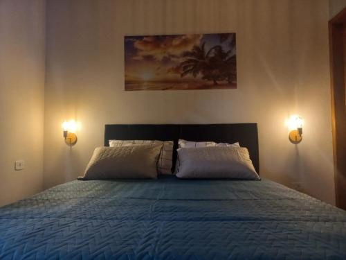 a bedroom with a bed with two lights on it at Recanto do Sossego in São Sebastião