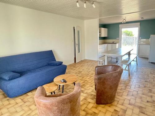 - un salon avec un canapé bleu, des chaises et une table dans l'établissement Maison contemporaine - 3 pièces - 700m plage et surf - Jardin privé, terrasse - Brétignolles-sur-Mer - FR-1-231-163, à Bretignolles-sur-Mer