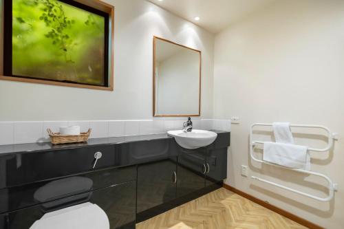 a bathroom with a sink and a mirror at Lakefront Cottage in Queenstown