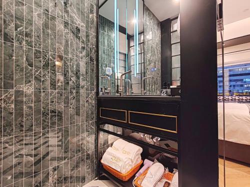 bagno con lavandino e specchio di Tang Palace Hotel - Beijing Sanlitun Gongti Store a Pechino