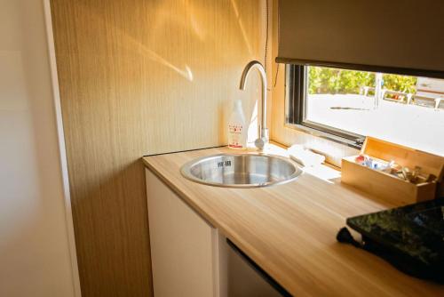 um balcão de casa de banho com um lavatório e uma janela em Pacific View em Leithfield