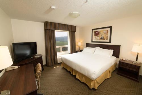 a hotel room with a bed and a television at Holiday Inn Express Hotel & Suites - Slave Lake, an IHG Hotel in Slave Lake