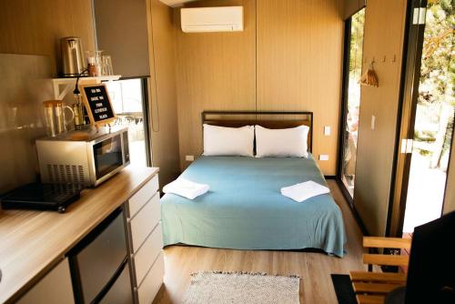 um pequeno quarto com uma cama e um micro-ondas em Pacific View em Leithfield