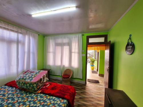 a bedroom with green walls and a bed and a window at Neoravalley Homestay, Icche Gaon in Pedong