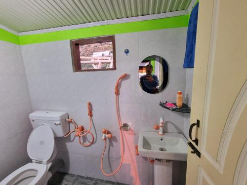a bathroom with a toilet and a sink and a mirror at Neoravalley Homestay, Icche Gaon in Pedong